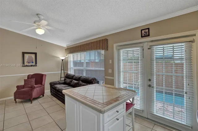 a living room with furniture a large window and kitchen view