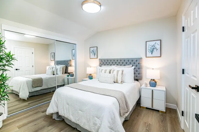 a bedroom with two beds and wooden floor