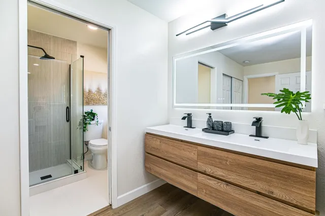 a bathroom with a granite countertop sink a mirror a vanity and a bathtub