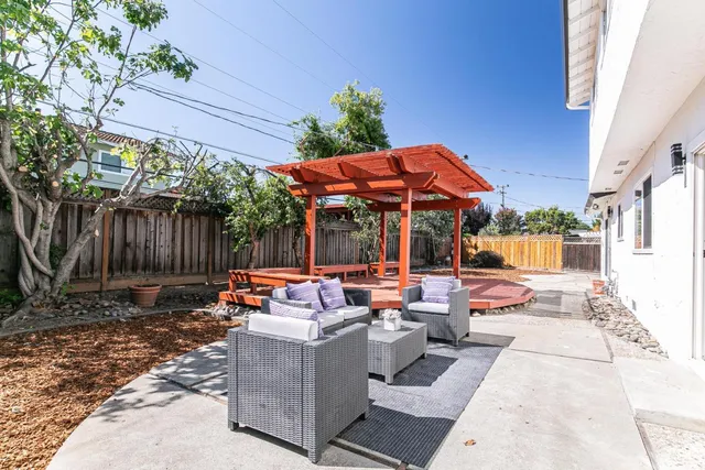 an outdoor sitting area with furniture and umbrella
