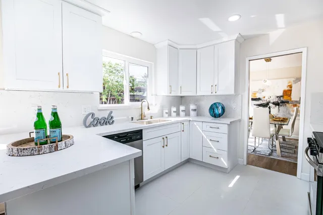 a kitchen filled with white cabinets and white appliances