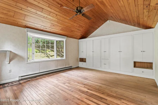 a view of a room with a large window and wooden floor