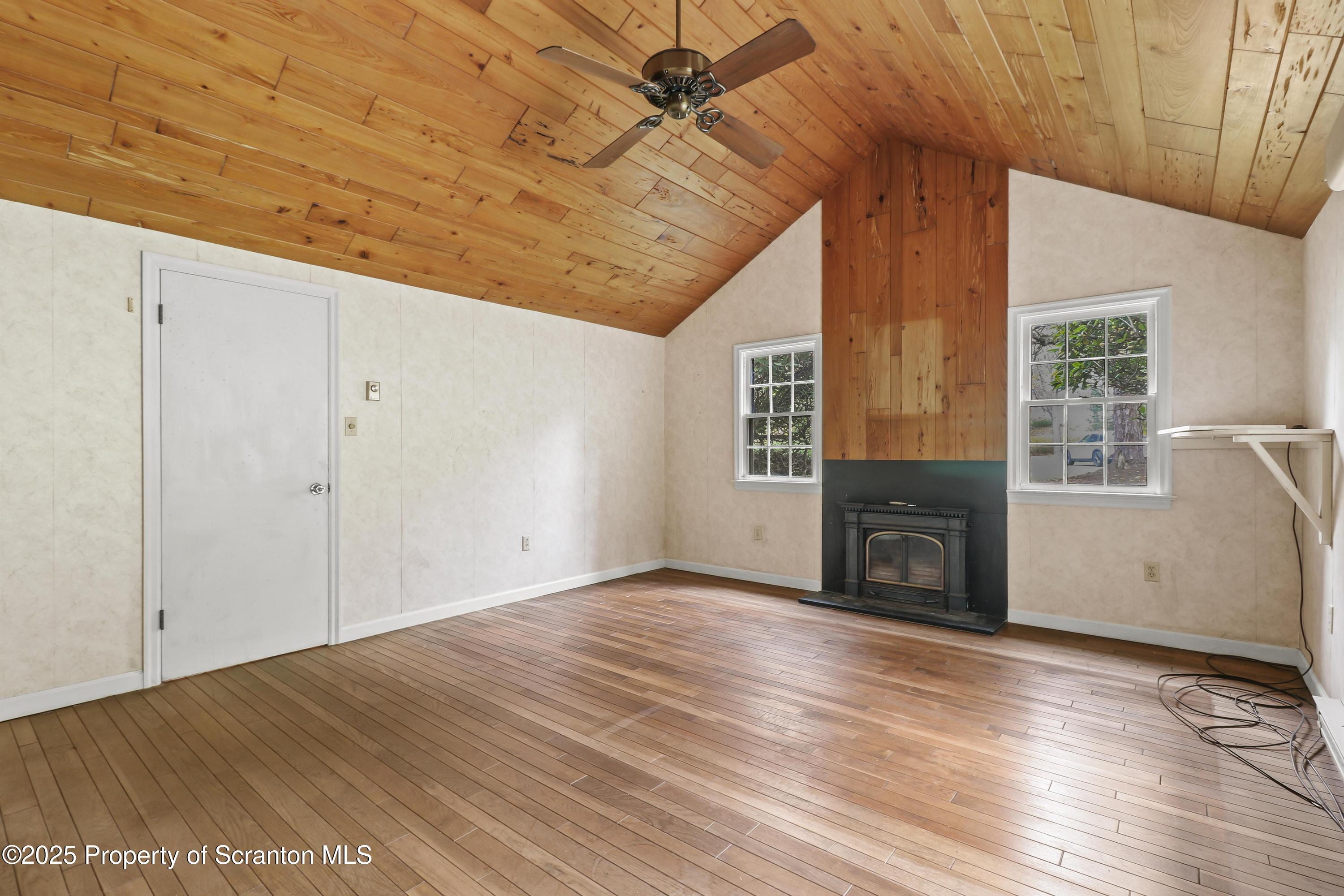 28 Church Hill Road Dalton, PA 18414 - Photo 18 of 63 a view of empty room with wooden floor and fireplace