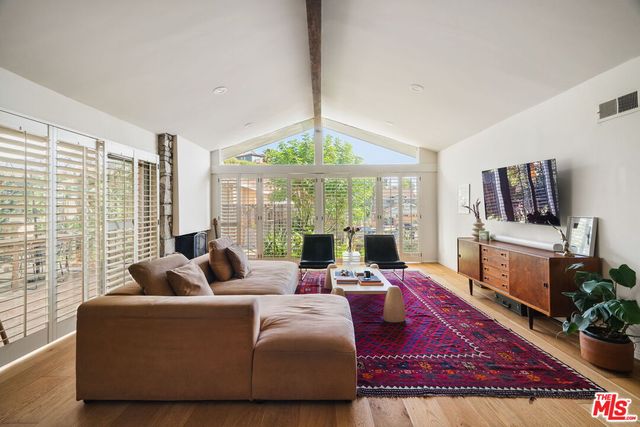 a kitchen with stainless steel appliances kitchen island granite countertop a table chairs in it and wooden floor