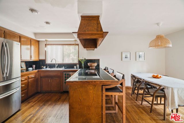 a kitchen with stainless steel appliances granite countertop a sink a stove and a wooden floors