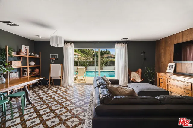 a living room with furniture and a floor to ceiling window