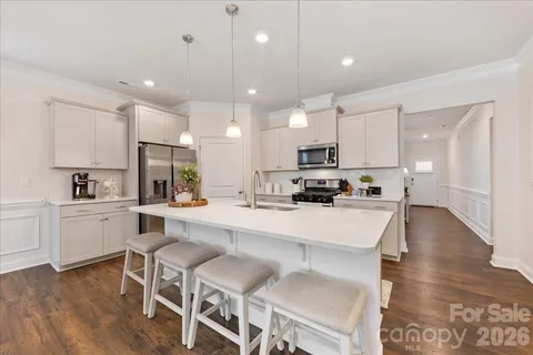 a kitchen with kitchen island cabinets and chairs