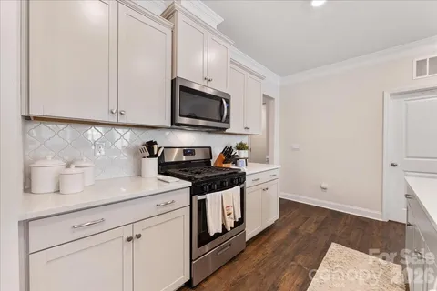 a kitchen with a sink a counter space and living room view
