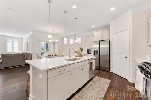 a kitchen with stainless steel appliances granite countertop a sink a stove and a refrigerator
