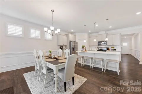 a view of a dining room with furniture a chandelier and wooden floor