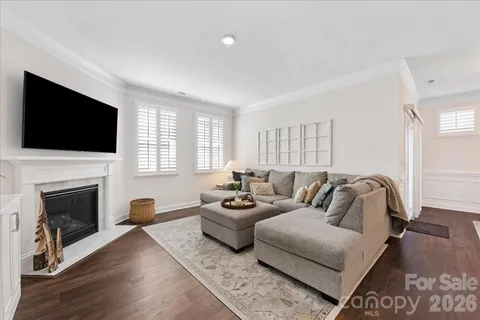 a living room with furniture and a view of kitchen