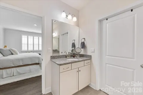 a bathroom with a granite countertop sink a mirror and shower