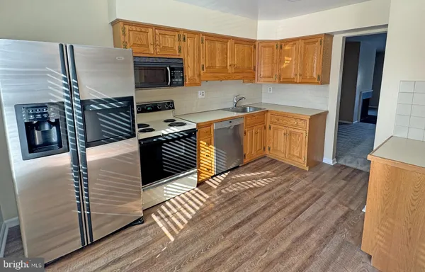 a kitchen with stainless steel appliances granite countertop a stove a sink and a refrigerator