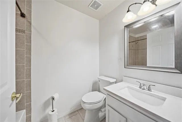 a bathroom with a granite countertop toilet a sink and mirror