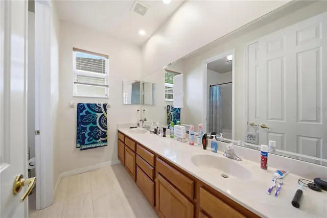 a bathroom with a double vanity sink a mirror and a bathtub
