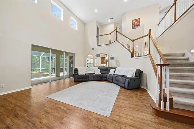 a living room with furniture floor to ceiling window and a wooden floor