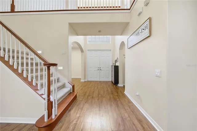 a view of a hallway with wooden floor and staircase