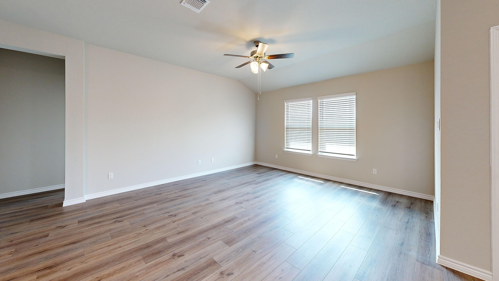 243 Water Wl Road Burnet, TX 78611 - Photo 9 of 23 Spacious room featuring wood-finish flooring, light-colored walls, and a ceiling fan with integrated lighting