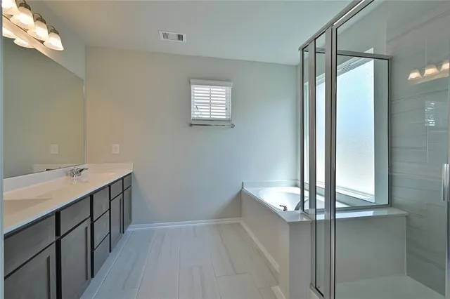 a bathroom with a tub sink and mirror