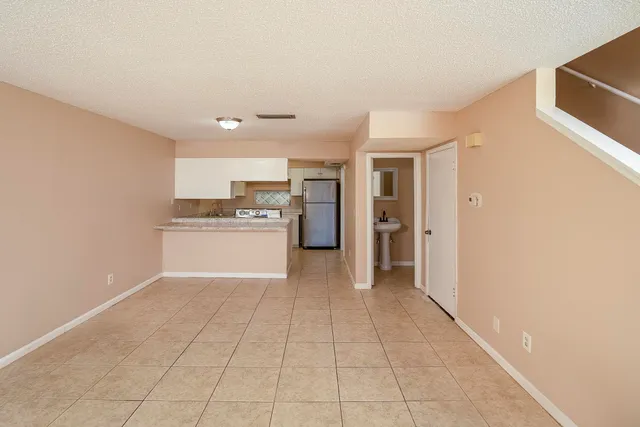 a view of a kitchen with a sink and a refrigerator