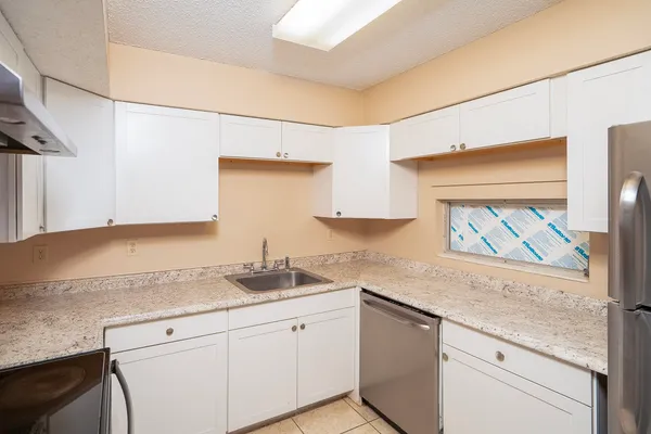 a kitchen with granite countertop stainless steel appliances a sink and cabinets