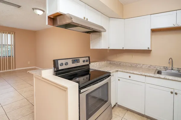 a kitchen with cabinets and steel appliances