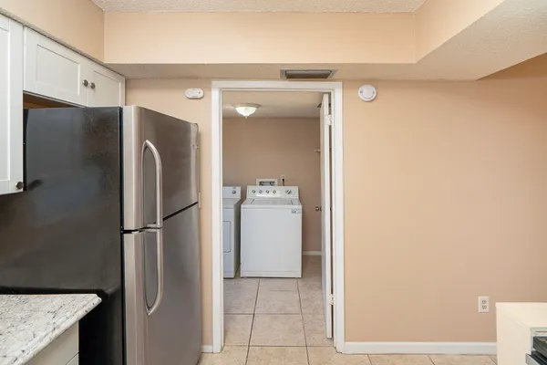 a walk in closet and a refrigerator in a kitchen