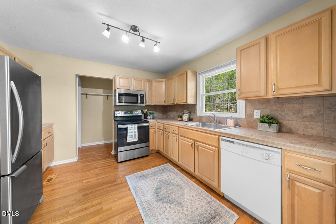 122 Stedwick Place Durham, NC 27712 - Photo 13 of 39 a kitchen with stainless steel appliances granite countertop a stove a sink dishwasher a refrigerator and a microwave oven