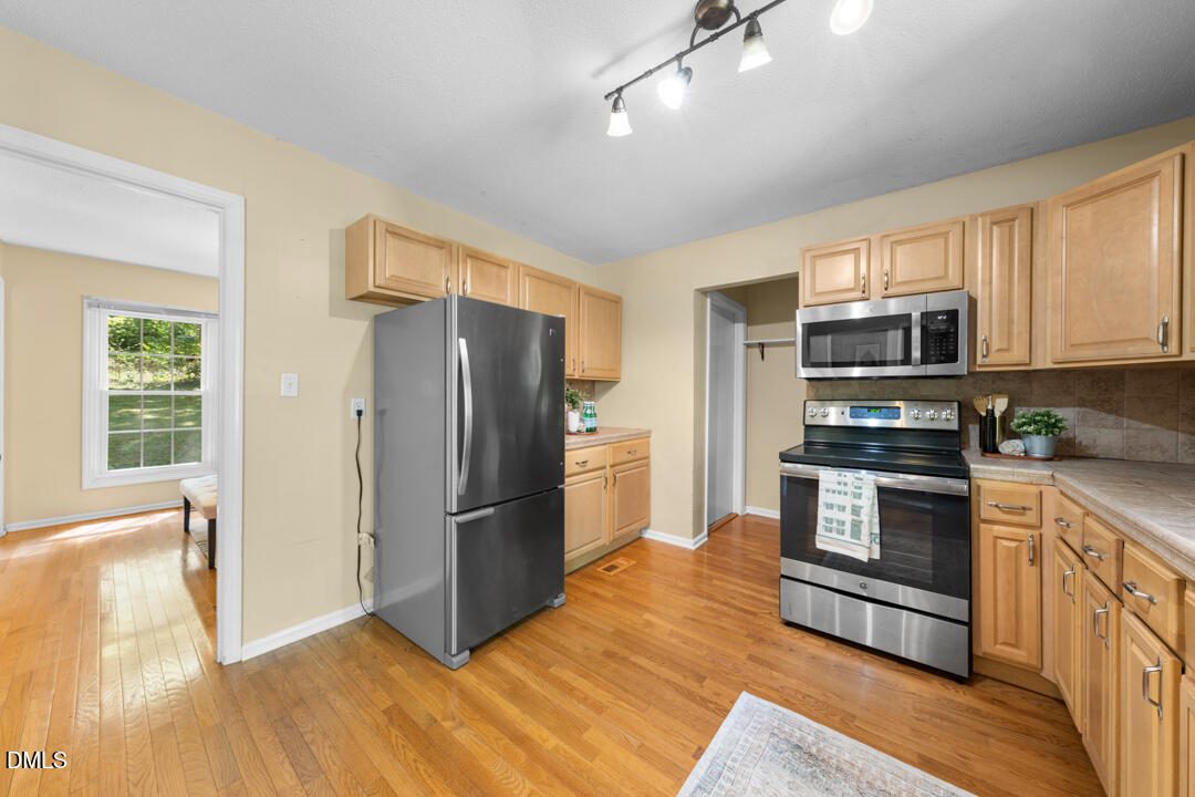 122 Stedwick Place Durham, NC 27712 - Photo 14 of 39 a kitchen with granite countertop a refrigerator stove and microwave