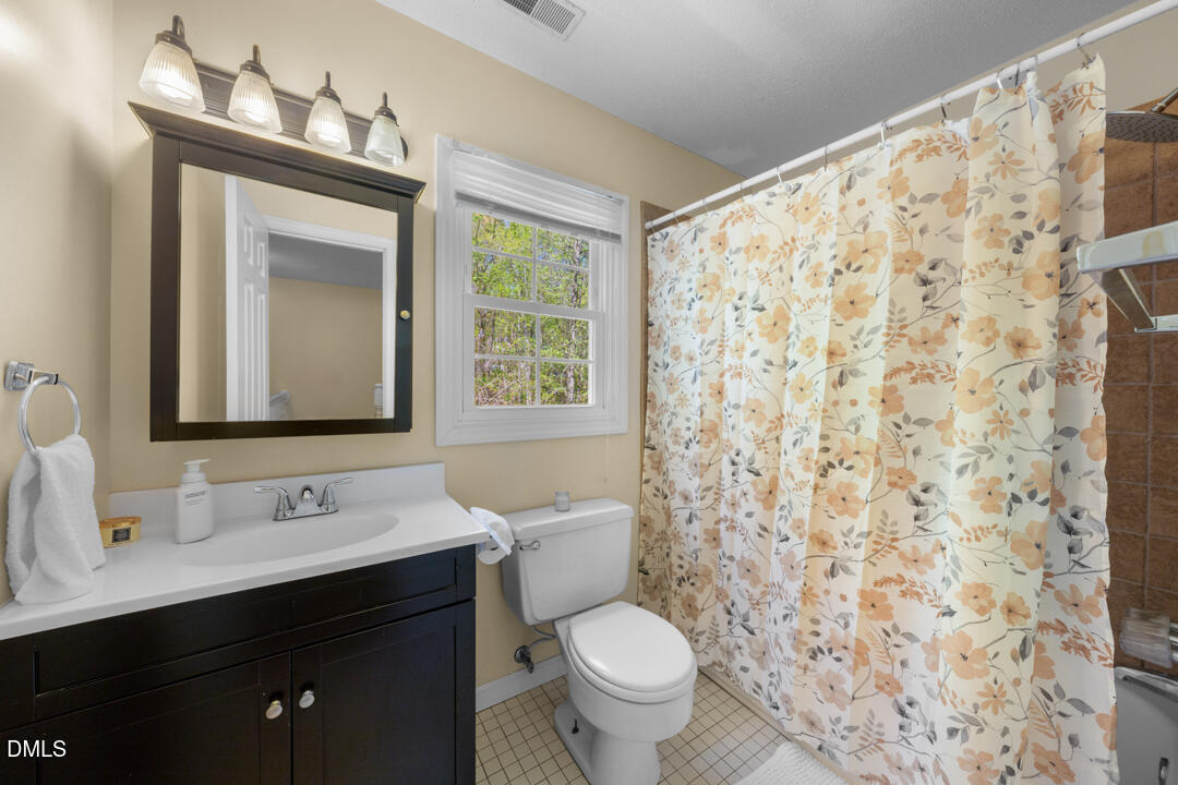 122 Stedwick Place Durham, NC 27712 - Photo 28 of 39 a bathroom with a granite countertop sink a toilet and a mirror