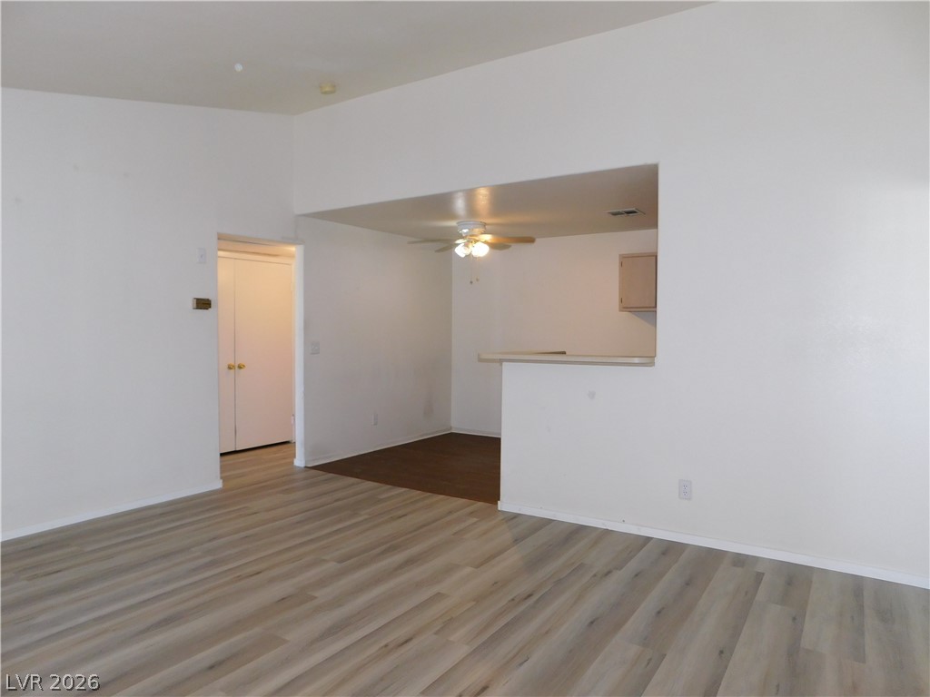 5221 South Lindell Road, Unit 202 Las Vegas, NV 89118 - Photo 8 of 28 An open concept living area transitions smoothly to a cozy kitchen space, featuring light wood flooring and a breakfast bar.