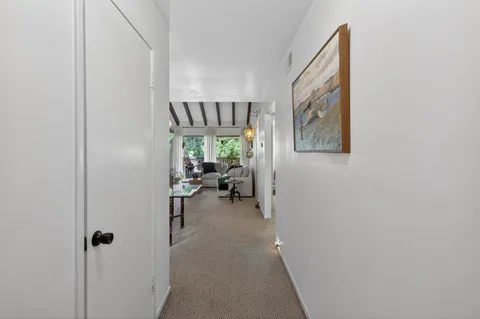 a view of a hallway with workspace and a window