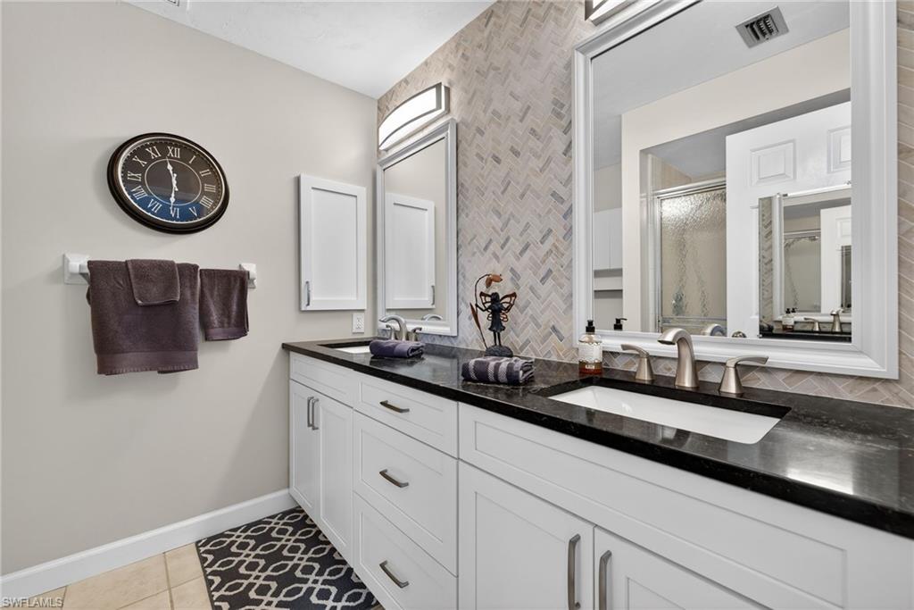 314 Reynolds Court Naples, FL 34112 - Photo 16 of 30 a bathroom with a sink and a mirror