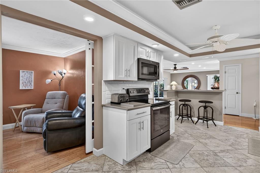 314 Reynolds Court Naples, FL 34112 - Photo 30 of 30 a living room with furniture a flat screen tv and kitchen view