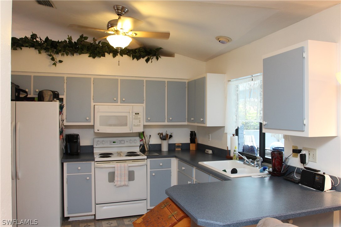 17485 Duquesne Road Fort Myers, FL 33967 - Photo 3 of 25 a kitchen with cabinets a sink a window and stainless steel appliances