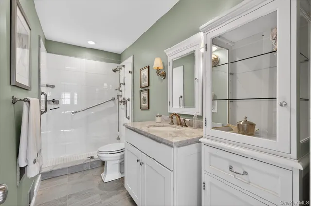 a bathroom with a granite countertop sink toilet and shower