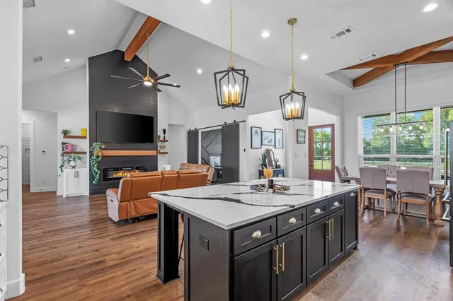 a kitchen with a stove chandelier and a view of living room