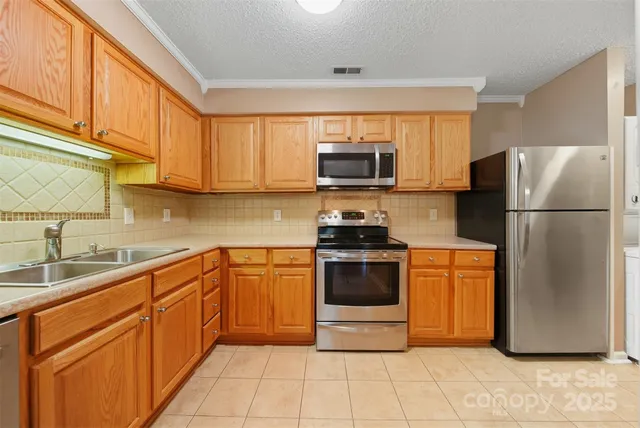 a kitchen with stainless steel appliances granite countertop a refrigerator sink and stove