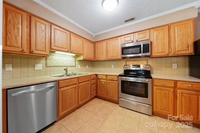 a kitchen with granite countertop cabinets stainless steel appliances and a sink