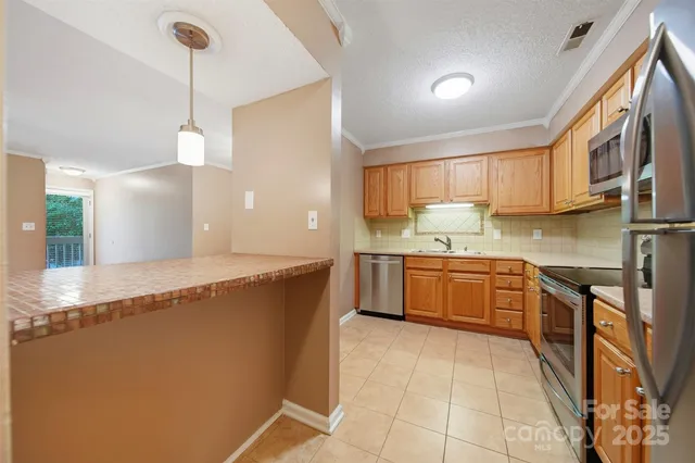 a large kitchen with a stove a sink a microwave and a refrigerator