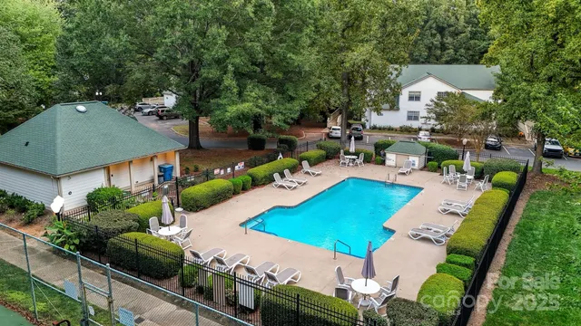 an aerial view of a house with swimming pool and outdoor seating