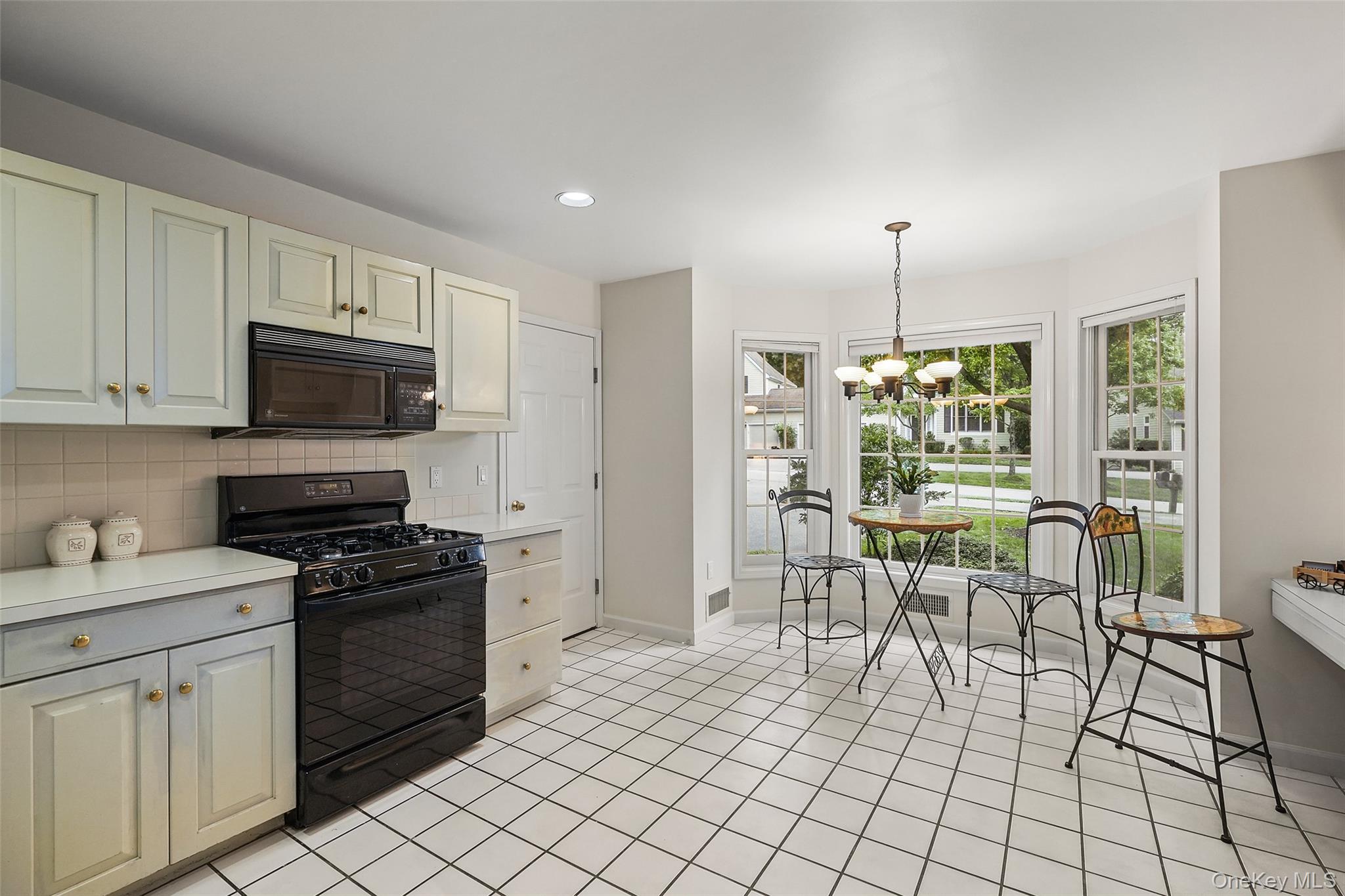 18 Cross River Road Mount Kisco, NY 10549 - Photo 11 of 30 a kitchen with stainless steel appliances a stove a sink cabinets and a dining table