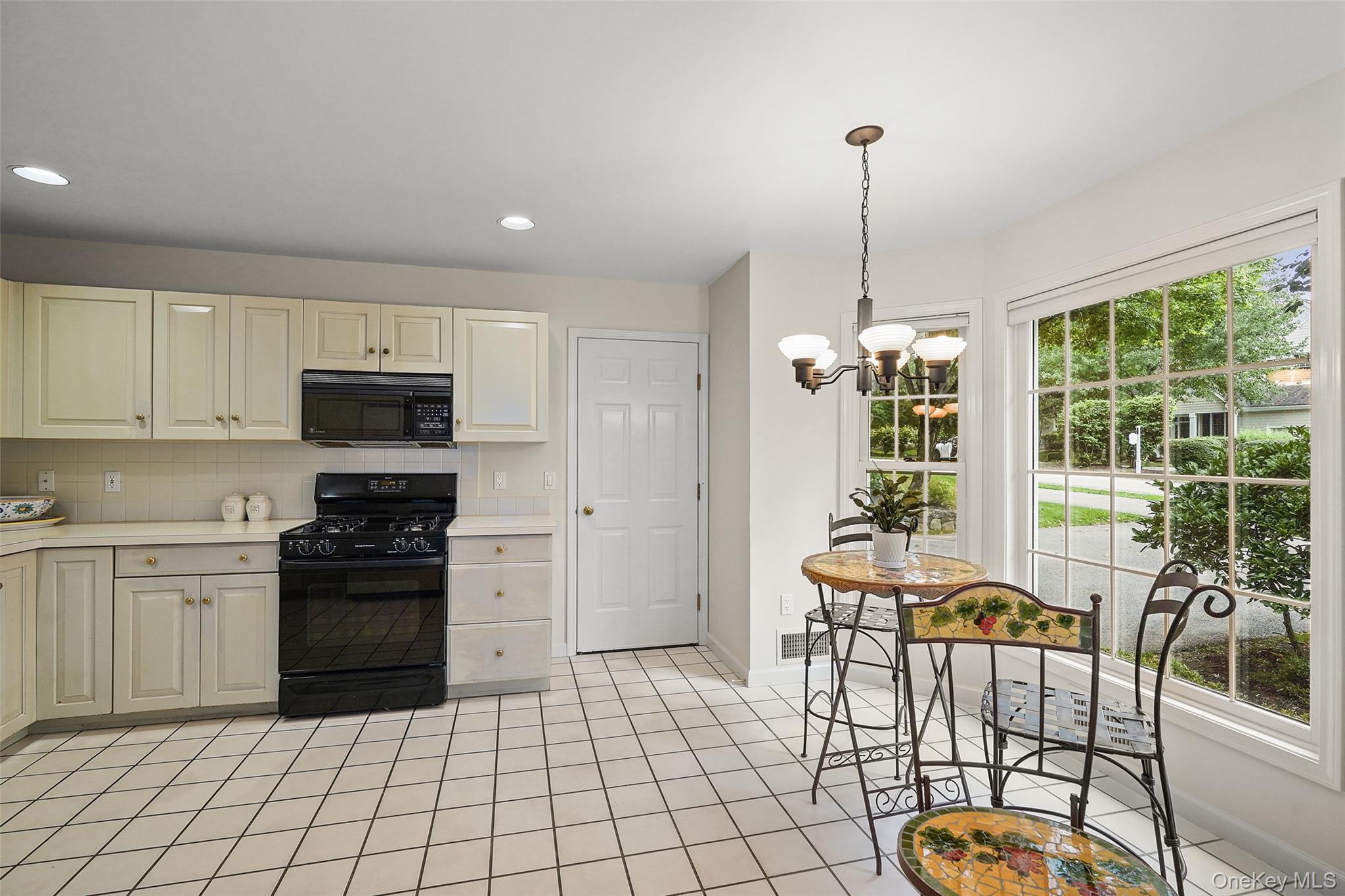 18 Cross River Road Mount Kisco, NY 10549 - Photo 13 of 30 a kitchen with stainless steel appliances granite countertop a stove a refrigerator a dining table and chairs with wooden floor