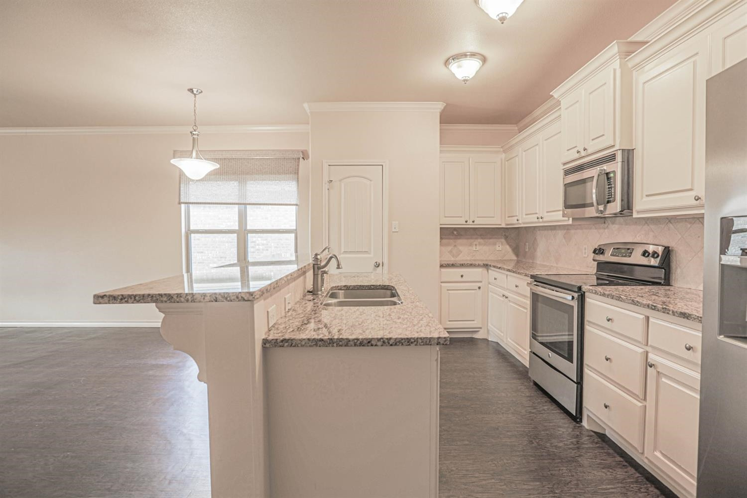 5019 Jarvis Street Lubbock, TX 79416 - Photo 5 of 31 a kitchen with kitchen island granite countertop white cabinets and white appliances