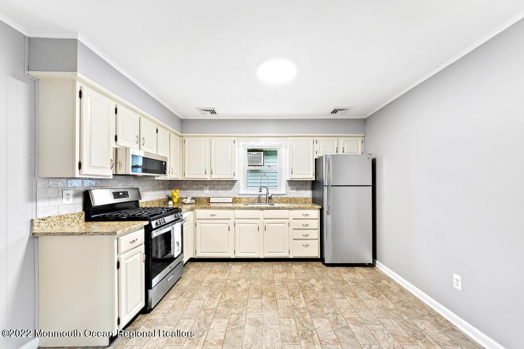 3 George Road Toms River, NJ 08753 - Photo 8 of 24 a kitchen with stainless steel appliances granite countertop a stove a refrigerator and a refrigerator