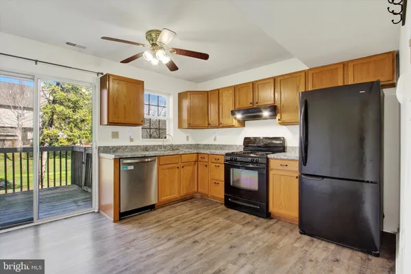 a kitchen with granite countertop a refrigerator stove top oven and sink
