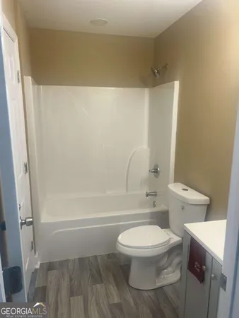 a white toilet sitting next to a bath tub