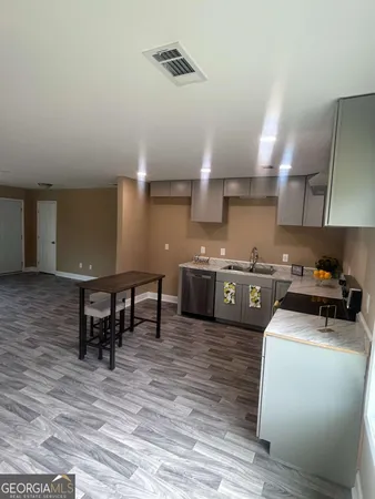 a kitchen with stainless steel appliances a sink a stove top oven a counter space and cabinets