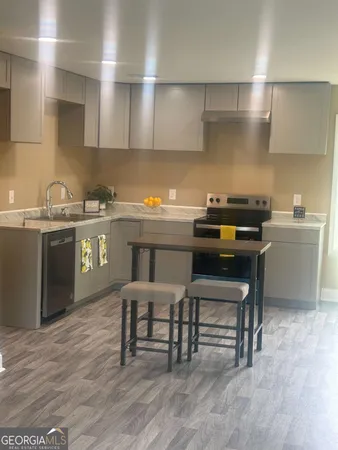 a kitchen with a stove a table and chairs in it