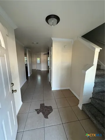 a view of entryway with stairs and a rug